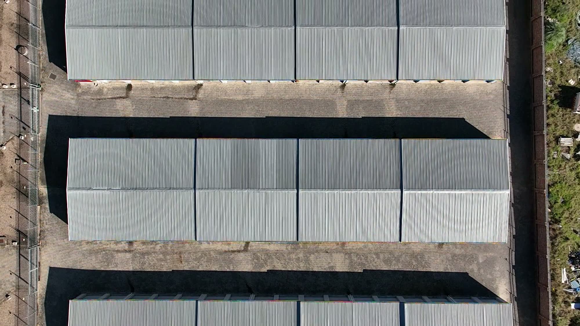 Top-down drone view across both phases of the facility
